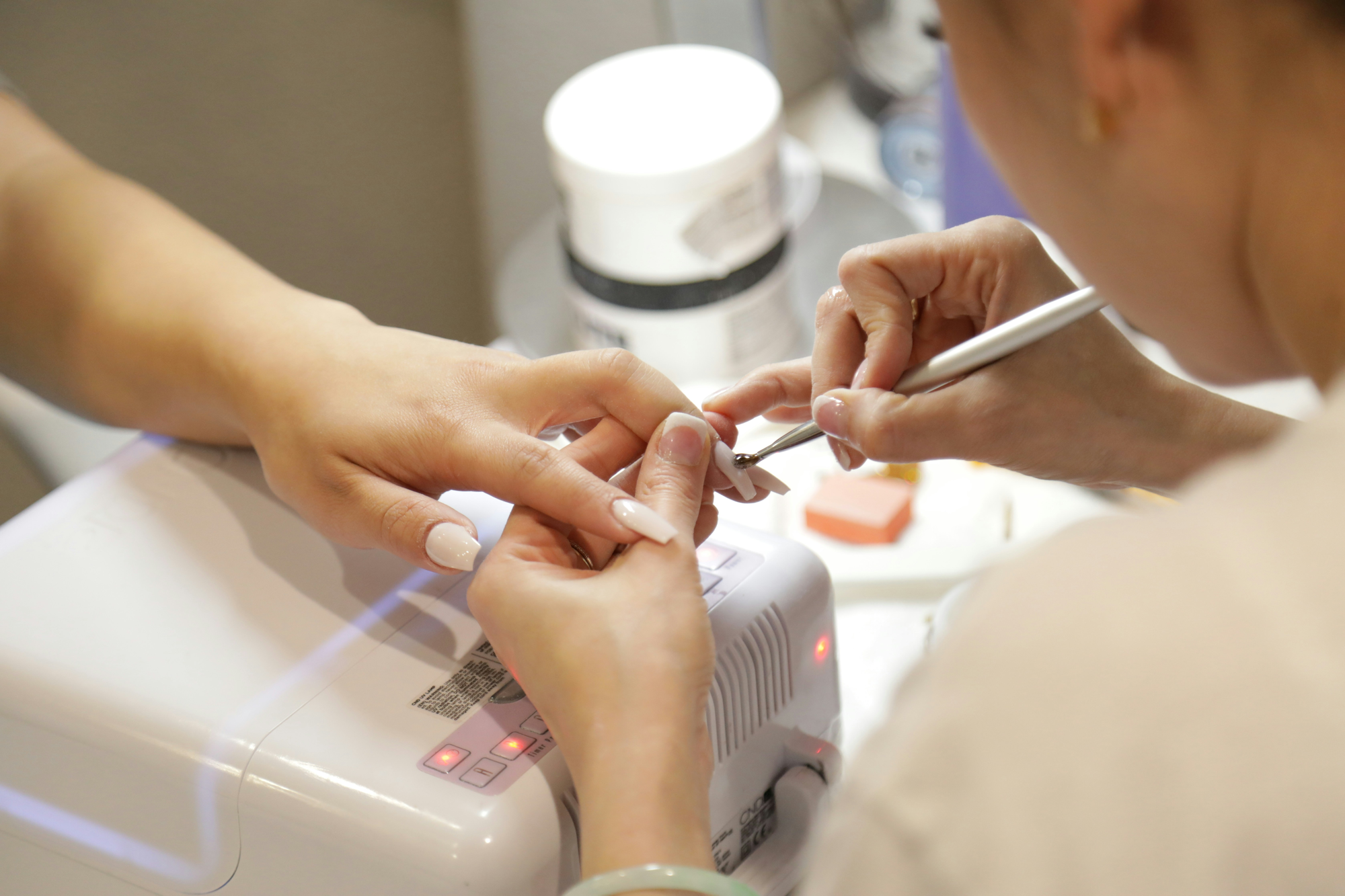 Nail technician carefully working on a client's nails
